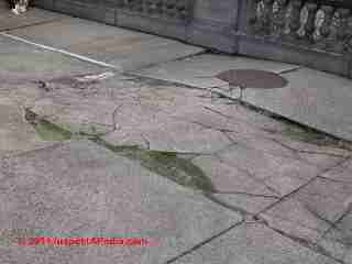 Photograph of a cracked and heaved concrete slab that had control joints