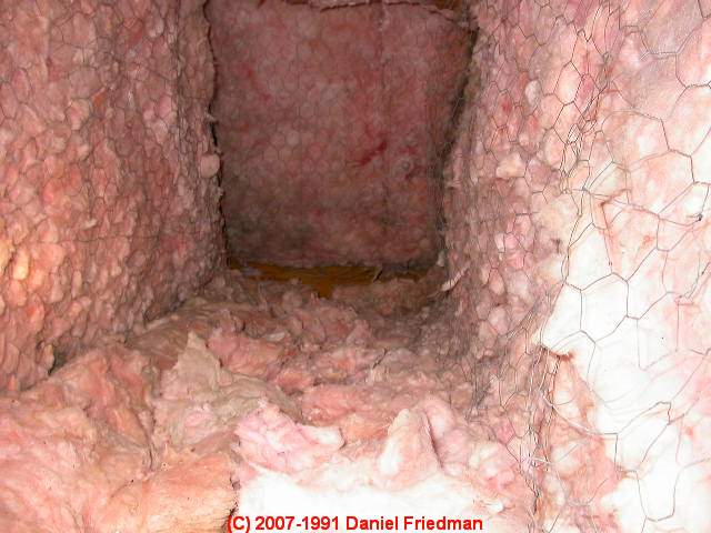 Photo of air ducts improperly lined with fiberglass batt insulation and chickenwire  (C) InspectApedia.com  