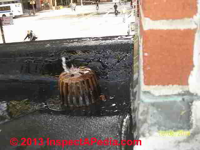 Overflowing at low slope roof drain floods apartment (C) InspectApedia BMR