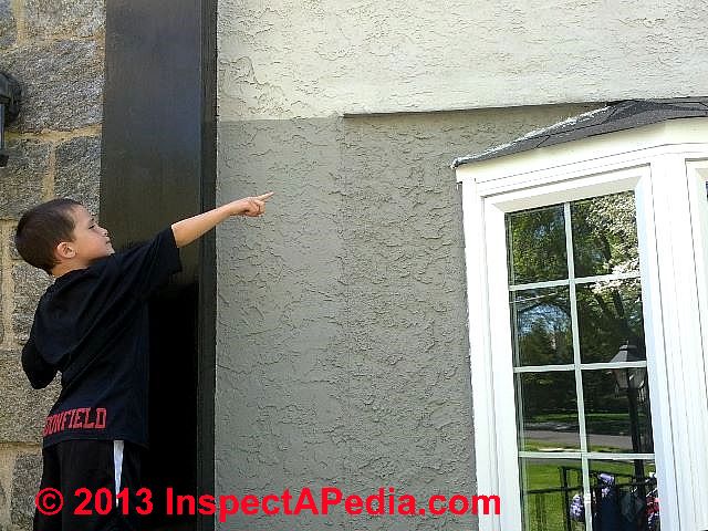 Tanner Daniel Gilligan points out a subsitution for roof-wall flashing over a bay window: the installer tried a wavy line of white caulk aghainst the gray stuco exterior. (C) Daniel Friedman Tanner Gilligan 2013