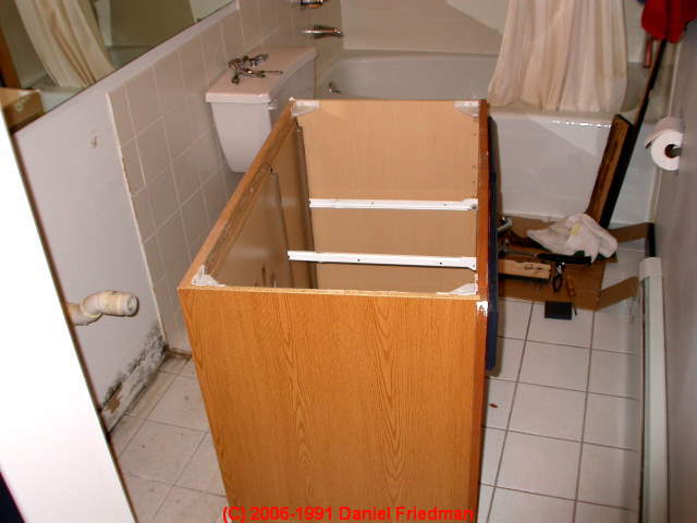 Photograph of inspecting below a bath vanity for hidden mold.