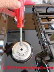 Using a 7mm nut driver to remove and install the brass gas orifice fittings on a Bosch gas cook top (C) Daniel Friedman