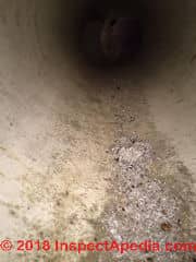 Dirt and water in plastic in-slab duct in a Minnesota home (C) Inspectapedia.com Reader N.