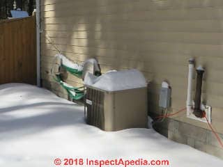 Snow covered heat pump (C) Daniel Friedman at InspectApedia.com