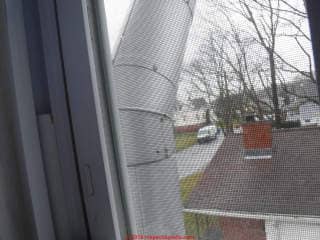 Stainless steel chimney close to exterior wall and window (C) InspectApedia.com anon
