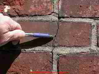 Photograph of a brick chimney cracked exterior, possibly due to heat.