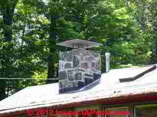 Stone cap over a chimney extends past chimney face (C) Daniel Friedman at InspectApedia.com