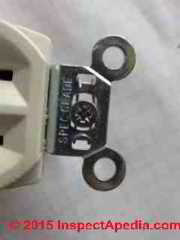 Metal box mender screw in a U.S. electrical receptacle mounting tab (C) Daniel Friedman