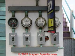 an outdoor electric meter and (below the hinged cover) main electrical switch at a building in Port Angeles, Washington. (C) InspectApedia.com Daniel Friedman