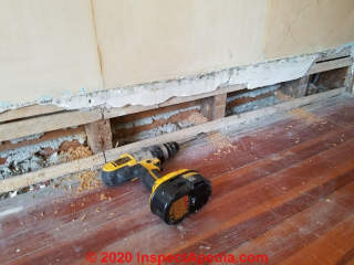 Drilling studs to route wire to add an electrical receptacle in an old house (C) Daniel Friedman at InspectApedia.com