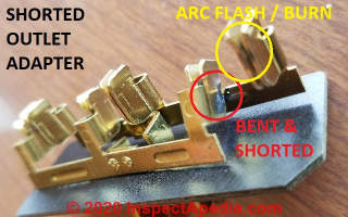 Shorted wall plug adapter shows arc flash burns on both the shorted contact between hot and neutral and also on the second wall plug spade connector (yellow) (C) Daniel Friedman at InspectApedia.com
