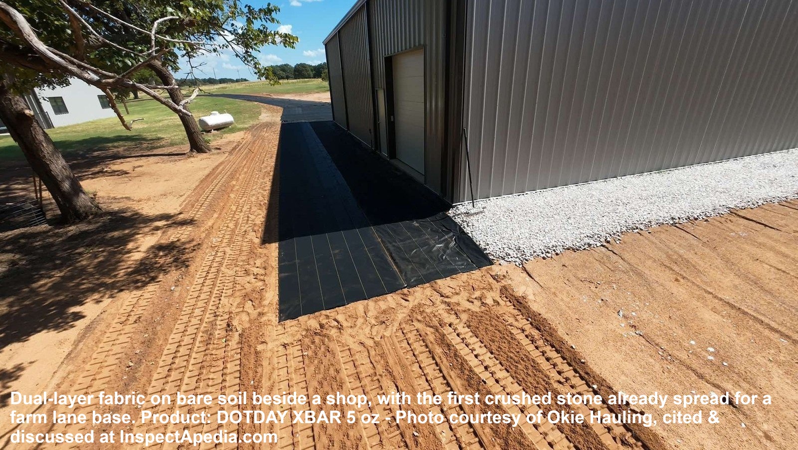 Geotextile fabric rolled out on bare soil with crushed stone spread on top for a farm lane. Cited at InspectApedia.com