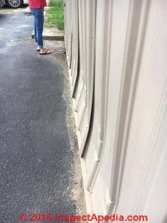 Crushing buckling aluminum siding on a commercial building needs more investigation (C) InspectApedia.com SD