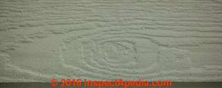 Characteristic identifying knot embossed in Certainteed fiber cement siding (C) InspectApedia.com DL