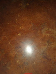 Scratches and White spots on brown-stained concrete floor (C) InspectApedeia.com Misty