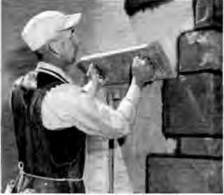 Permastone or Formstone being applied using a pre-formed die pressed into the stucco top coat -  McKee 1995 cited at InspectApedia.com
