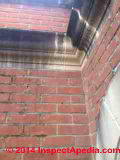 Black stains on re-constituted sandstone on  a building exterior (C) InspectAPedia C&D