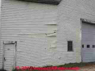 Buckled torn vinyl siding due to building movement (C) Daniel Friedman