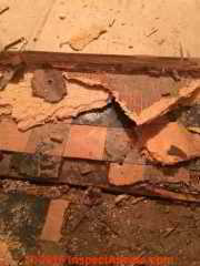 Asbestos-containing floor tiles in poor condition, producing some friable material, are unsafe (C) InspecApedia.com