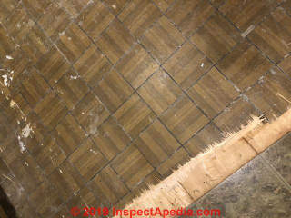 Vinyl floor tiles in wood parquet pattern may contain asbestos (C) InspectApedia.com
