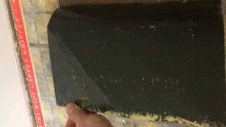 Asphalt coating on underside of an asbestos-suspect floor (C) InspectApedia.com Curtis