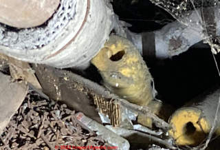 Corrugated asbestos pipe insulation and yellow fiberglass insulation (C) InspectApedia.com Steve S