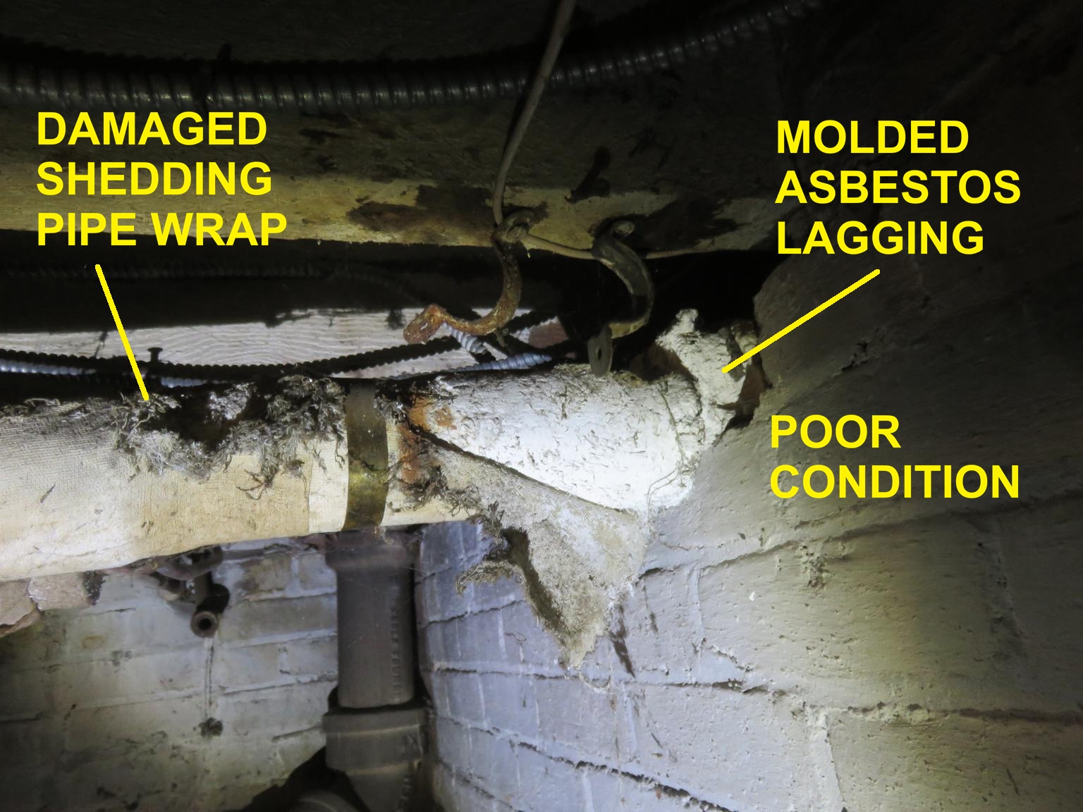 Deteriorated damaged asbestos pipe insulation (C) InspectApedia.com 79 Raymond Ave Pok