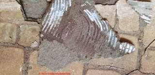 Asbestos likely in this brown-fibre backed white brick floor covering (C) InspectApedia.com Carter