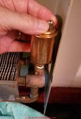 Loosen the valve stem cap atop the air eliminator so that it can automatically vent air (C) Daniel Friedman at InspectApedia.com