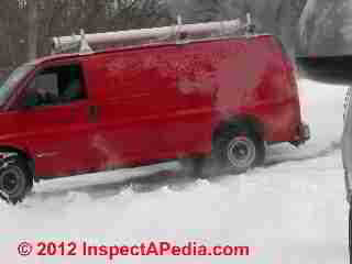 Disappointing oil heat service technician in a big rush to leave the job, spins his wheels and cuts a smoky cloud on driving off in the snow (C) Daniel Friedman at InspectApedia.com