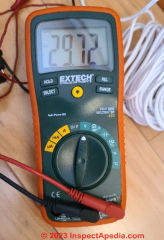 Using  a DMM to test the output voltage of a Nest C-wire add-on kit's transformer (C) Daniel Friedman at InspectApedia.com