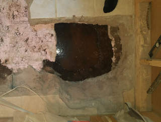 Water below concrete slab can leak up through foam insulation, concrete, and tile if conditions permit (C) Daniel Friedman at InspectApedia.com