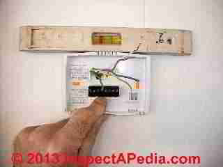 Positioning new wall thermostat in place (C) Daniel Friedman