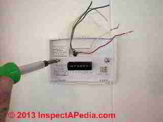 Positioning new wall thermostat in place (C) Daniel Friedman