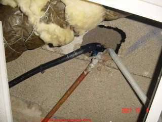 Yellow fiberglass insulation over rainwater drainage pipe in Spain (C) InspectApedia.com Jesua
