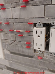 Using tile spacers to keep vertical wall tile installation grout joints uniform (C) InspectApedia.com A Church
