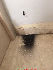 Unidentified black sooty stain on a bath wall and floor (C) InspectApedia.com Karen M