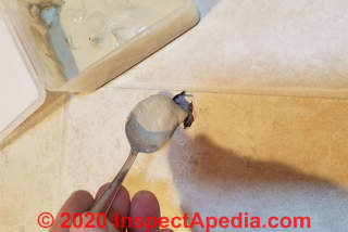 Spoon the soft grout into the area of damage on the tile floor (C) Daniel Friedman at InspectApedia.com