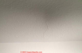 Ceiling/wall drywall cracks, damage, where roof trusses pass over non-load-bearing wall (C) InspectApedia.com Benefiel
