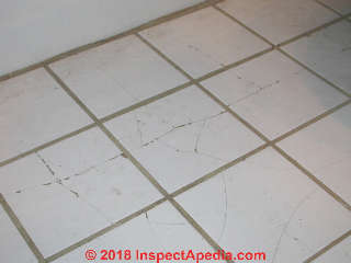 Fractured cermaic tile probably over damaged or inadequate subfloor or inadquate framing (C) Daniel Friedman Inspectapedia.com reader Gorey