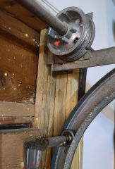 Automatic overhead garage door lift cable pulley and door wheel exposure hazards (C) Daniel Friedman at InspectApedia.com
