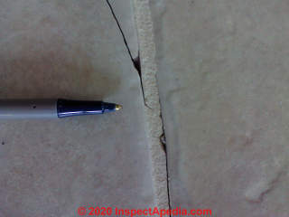 Closeup of ceramic tile crack caused by concrete slab defects: no control joints, cold weather (C) Daniel Friedman at InspectApedia.com