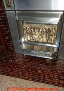 Green & black stains on ceramic surface of gas fireplace (C) InspectAPedia SH 
