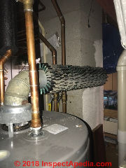 Fins on gas water heater vent extract heat to surrounding area, possible subtle safety hazard (C) InspectApedia.com MH
