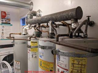 Four gas water heaters vented into a common flue, under-sized, improper, leaky, unsafe (C) InspectApedia.com Nesbitt