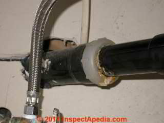 Leak at the slip joint coupling  nut on an ABS plastic drain trap (C) Daniel Friedman InspectApedia.com