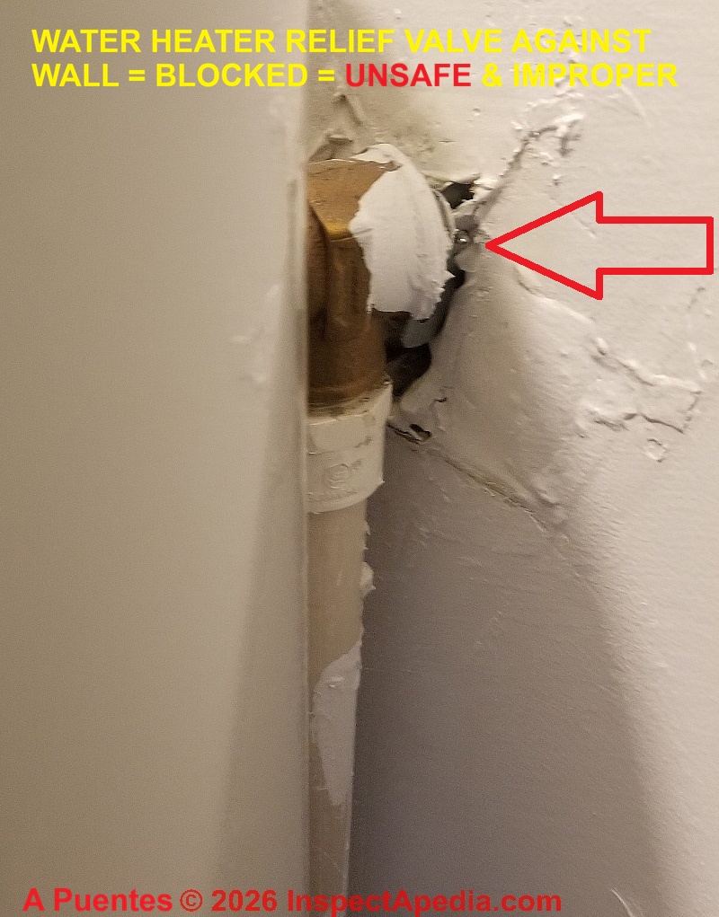 Unsafe, water heater relief valve is against wall, inaccessible, and worse, may not be able to open. (C) A Puentes InspectApedia.com