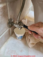 Adjustable wrench makes loosening and removing the toilet water supply riser easy.  (C) Daniel Friedman at InspectApedia.com
