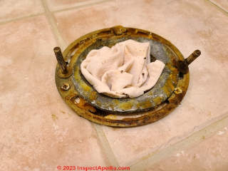 Toilet main drain, temporarily blocked by a rag, ready to receive a new toilet and its own new wax ring seal (C) Daniel Friedman at InspectApedia.com