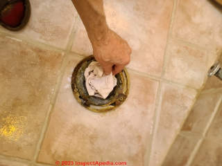 Remember to remove the safety rag from the toilet drain opening before placing the toilet in position (C) Daniel Friedman at InspectApedia.com